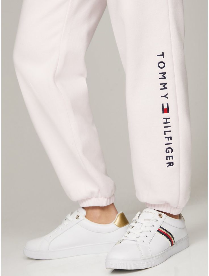 Tommy Hilfiger women's pant. Ideal for year-round wear, our medium weight sweatpants are made from cotton-blend fleece that feels soft against the skin. Designed with slash side pockets, an elastic waistband with an internal drawstring, and elastic cuffs, this sporty pair is made complete with our embroidered logo at the leg.  Material: 70% Better Cotton Initiative (bci) Cotton, 30% Polyester. Sporty Spring Joggers For Elevated Casual Wear, Casual Jogging Sweatpants With Logo, White Casual Bottoms With Logo Detail, Casual White Bottoms With Logo Detail, Casual Bottoms With Embroidered Logo For Loungewear, Sporty Sweatpants For Elevated Casual Spring, Sporty White Joggers For Fall, Trendy White Jogging Bottoms, Trendy White Joggers For Jogging