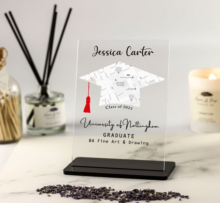 a clear acrylic plaque with a graduation cap and tassels on it