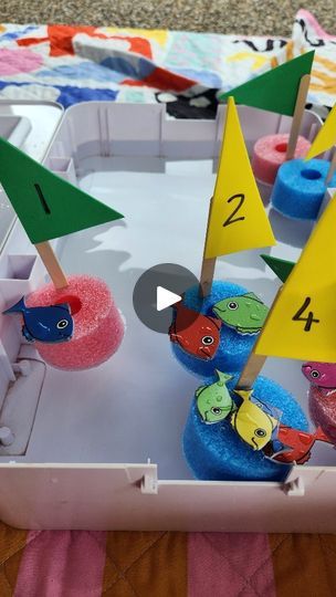 an open box with some little boats in it and numbers on the top of them