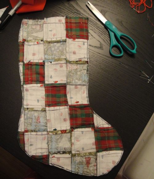 a quilted stocking sitting on top of a table next to scissors