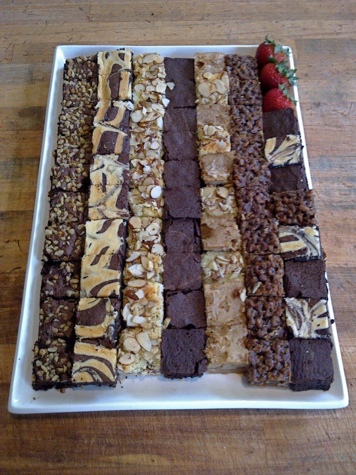 a white plate topped with lots of different types of desserts on top of a wooden table