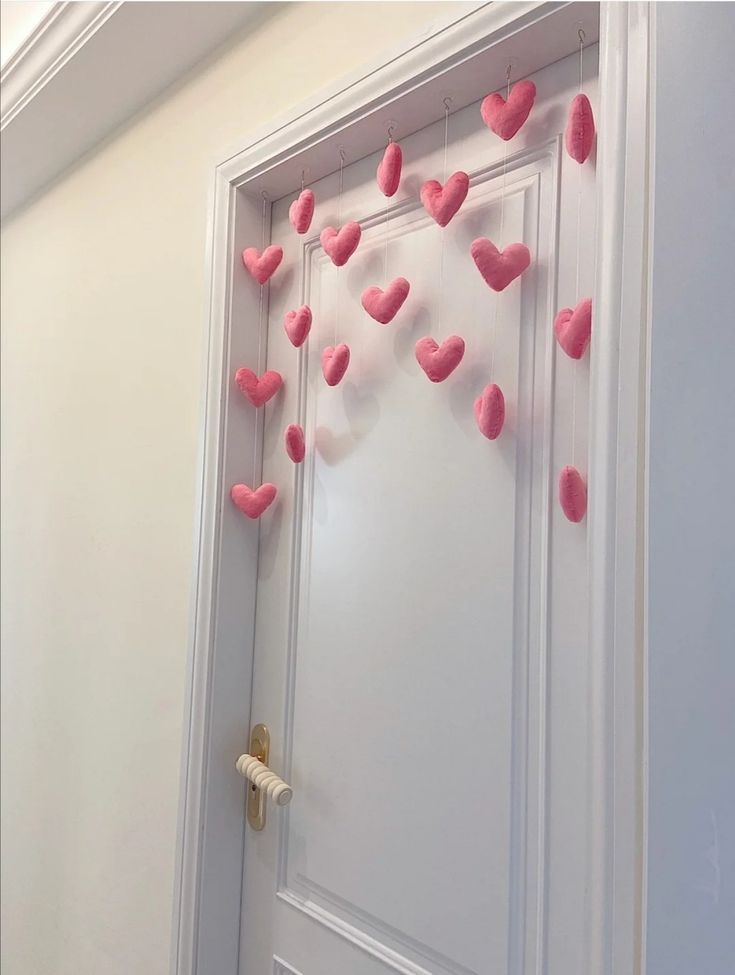 a door decorated with pink hearts hanging from it's side and on the wall