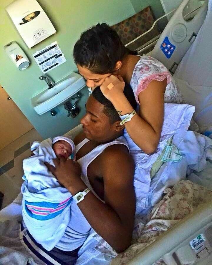 a man holding a baby in a hospital bed