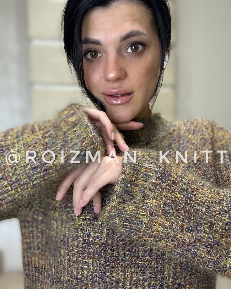 a woman with black hair wearing a sweater