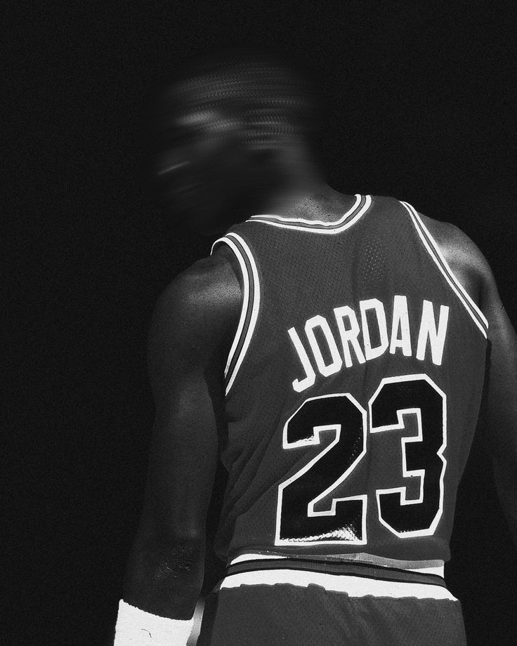 the back of a basketball player's jersey in black and white with blurry background