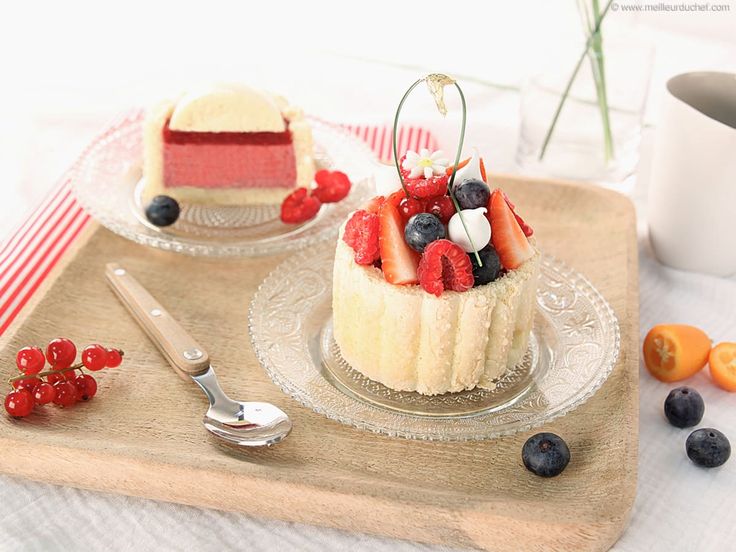 two small cakes with berries and blueberries on a tray