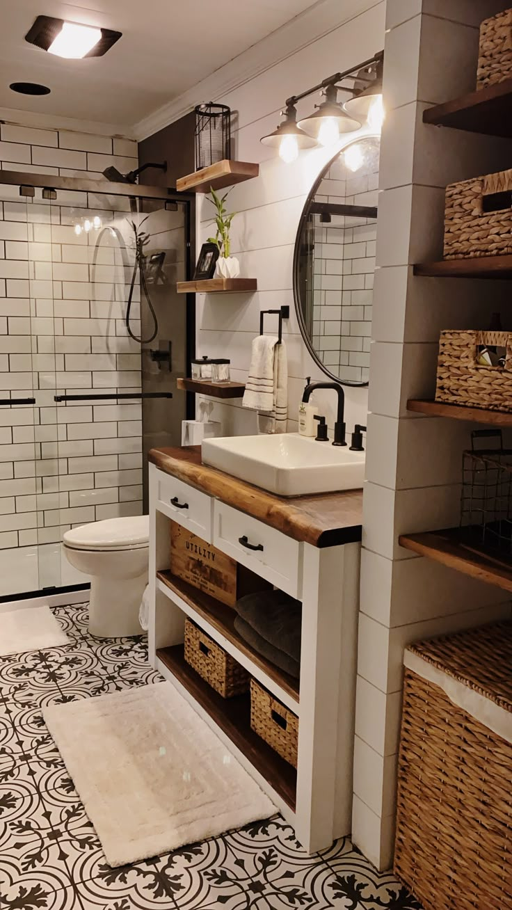 a bathroom with a sink, toilet and shower in it's stall area that has baskets on the floor