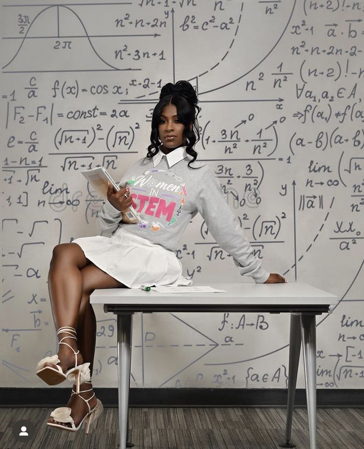 a woman sitting on top of a white table next to a wall covered in writing