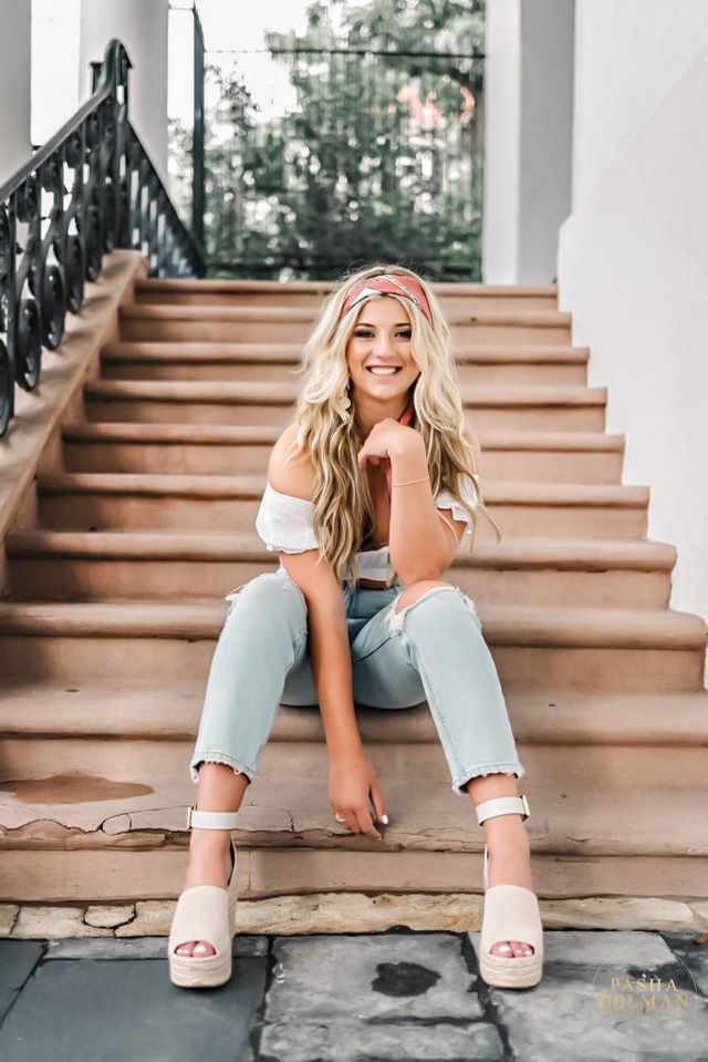 a beautiful blonde woman sitting on the steps