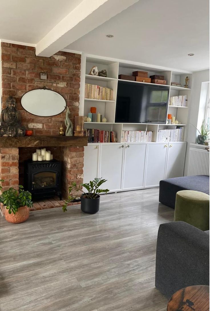 a living room filled with furniture and a fire place next to a wall mounted tv