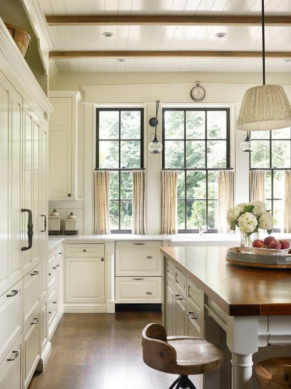 a large kitchen with white cabinets and wooden counter tops, along with an island in the middle