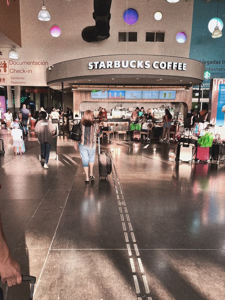 people are walking through an airport with their luggage