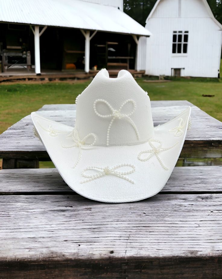 Baby features the daintiest of pearl bows adorning the a clean white hard canvas cowboy hat. Proudly American Made. Our hats are manufactured in Mexico and details added by hand in Los Angeles, CA using the highest quality materials. Sizing S/M 19in-22.75in | 48cm-57.5cm L/XL 19.5in-23.25in | 49.5cm-59cm *Please allow up to 2 weeks for production and shipping. Garden Party Bridal Shower, White Cowboy Hat, Parisian Summer, Bridesmaid Duties, Baby L, Bridal Fabric, Bach Party, Welcome To The Party, Hand Painted Rocks