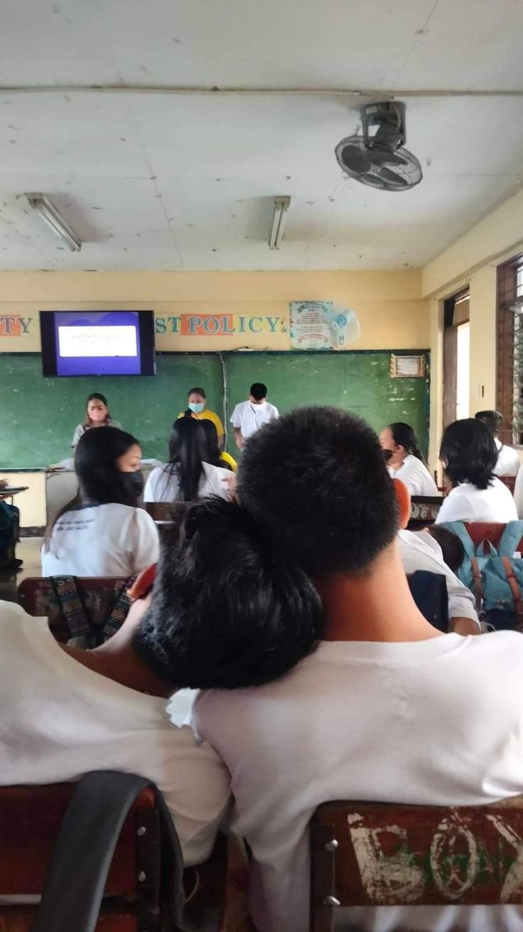 several people are sitting in front of a blackboard