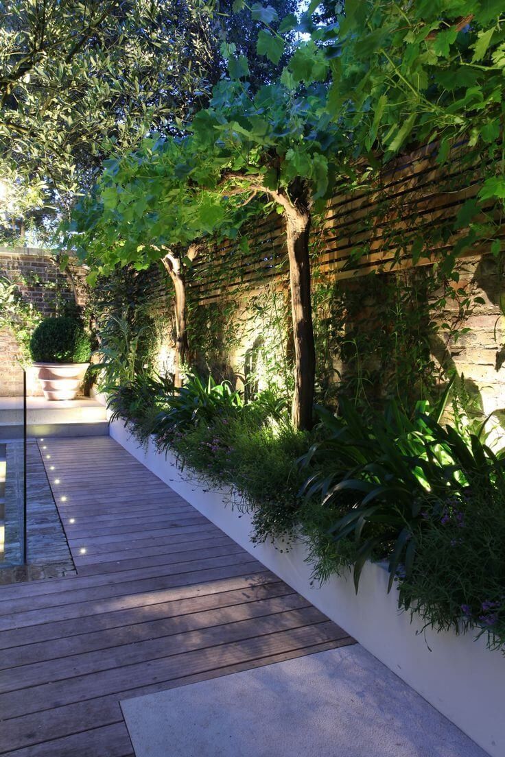 an outdoor area with wooden floors and plants on the wall