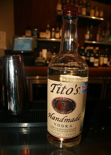 a bottle of tito's handmade vodka sitting on a bar counter top