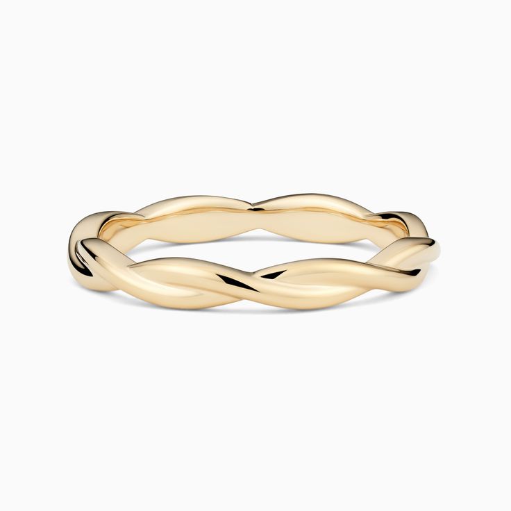 a yellow gold wedding band with twisted design in the middle, on a white background