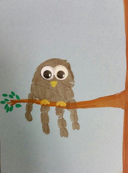 a handprinted owl sitting on a tree branch