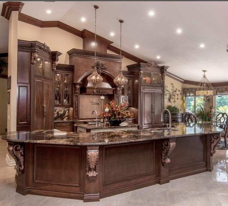 a large kitchen with marble counter tops and wooden cabinets, along with an island in the middle