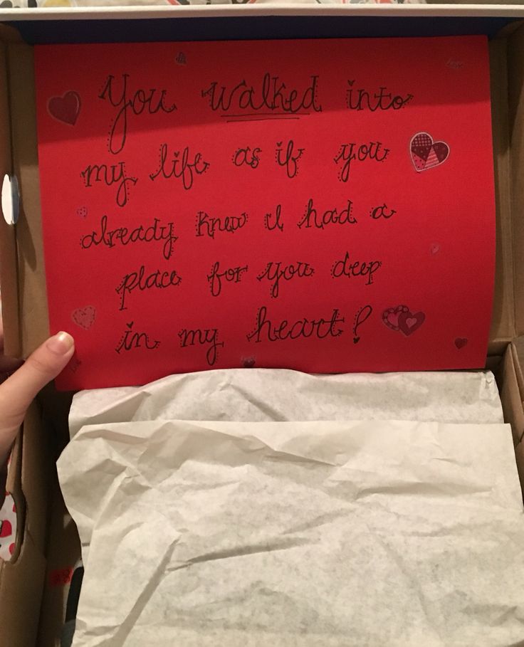 someone's hand is holding a piece of paper in a box with writing on it