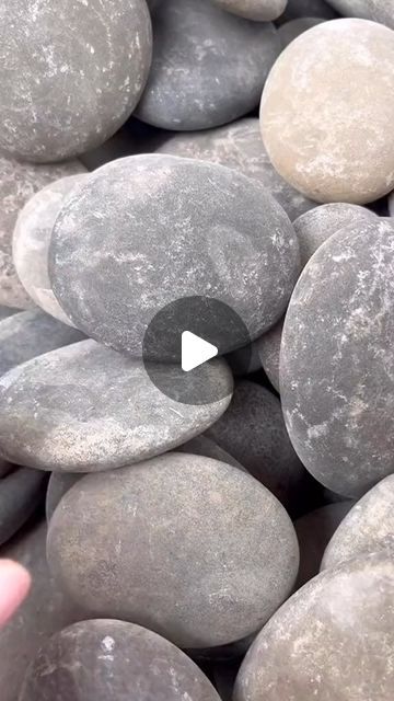 a person is touching some rocks with their thumbnails and pointing to the camera