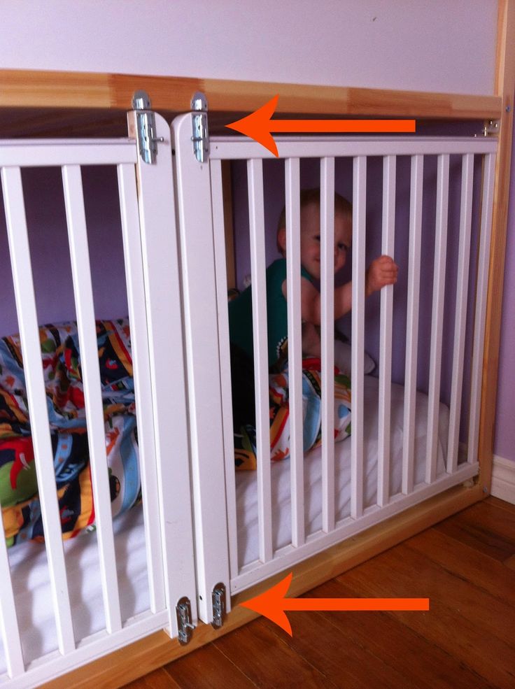 the baby is in his crib with two orange arrows pointing to it