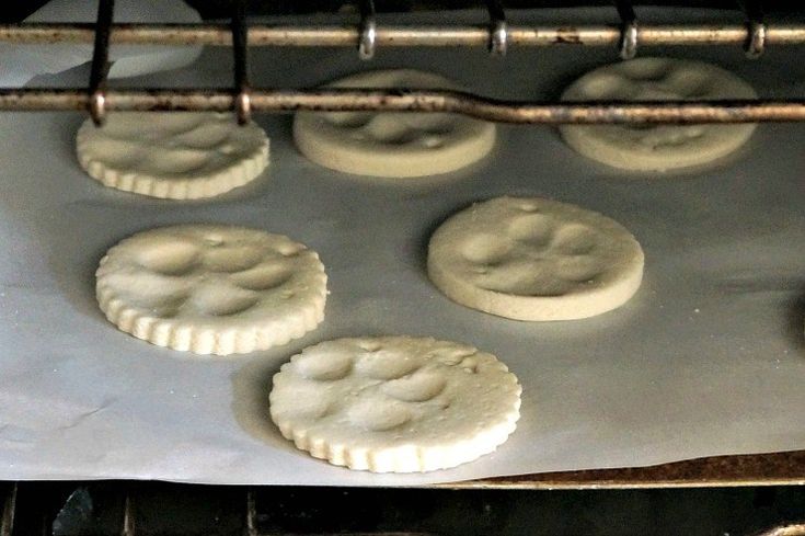 six uncooked doughnuts sitting on top of a baking sheet in an oven