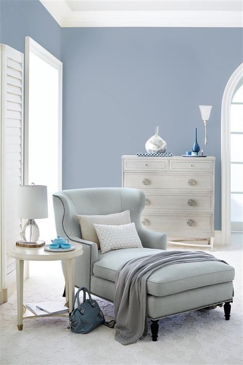 a living room with blue walls and white furniture