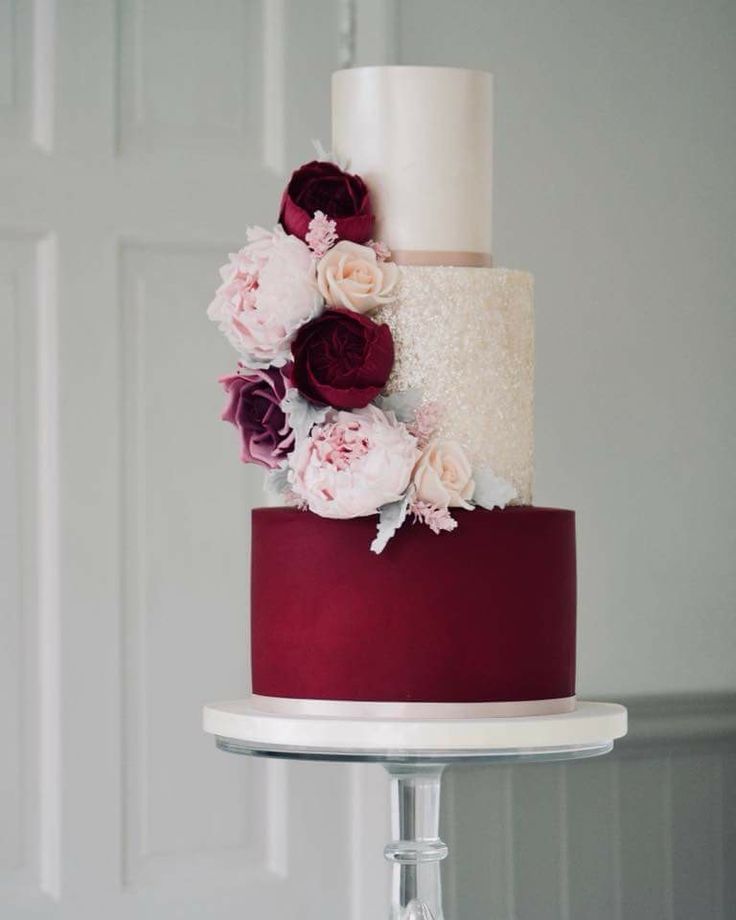 a three tiered cake with flowers on top