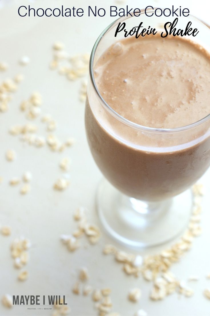 chocolate no bake cookie protein shake in a glass with oats scattered around it