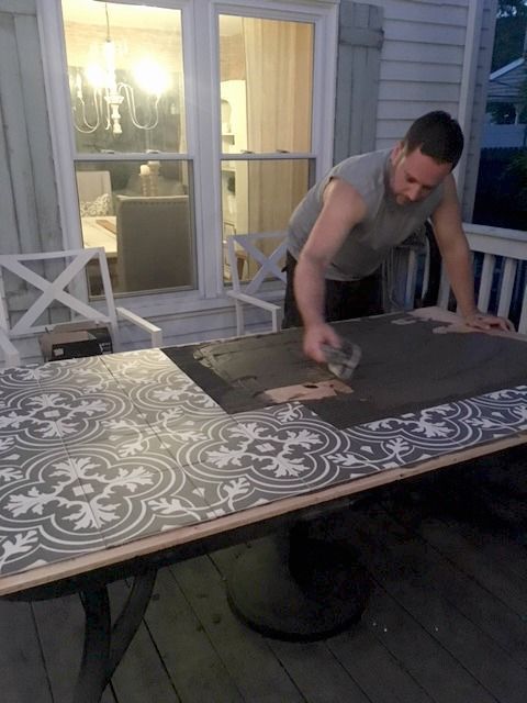 a man is working on an outdoor table