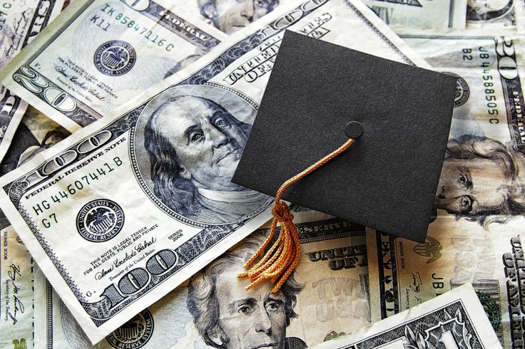 a graduation cap sitting on top of money