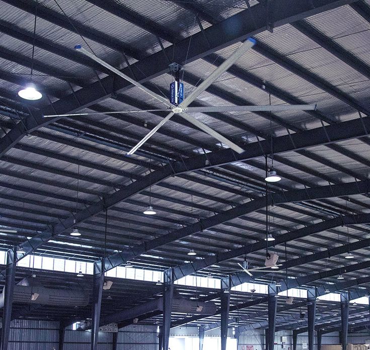 an empty warehouse with ceiling fans and lights