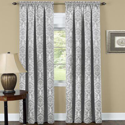 the curtains are hanging in front of a window with white and gray damasks on it