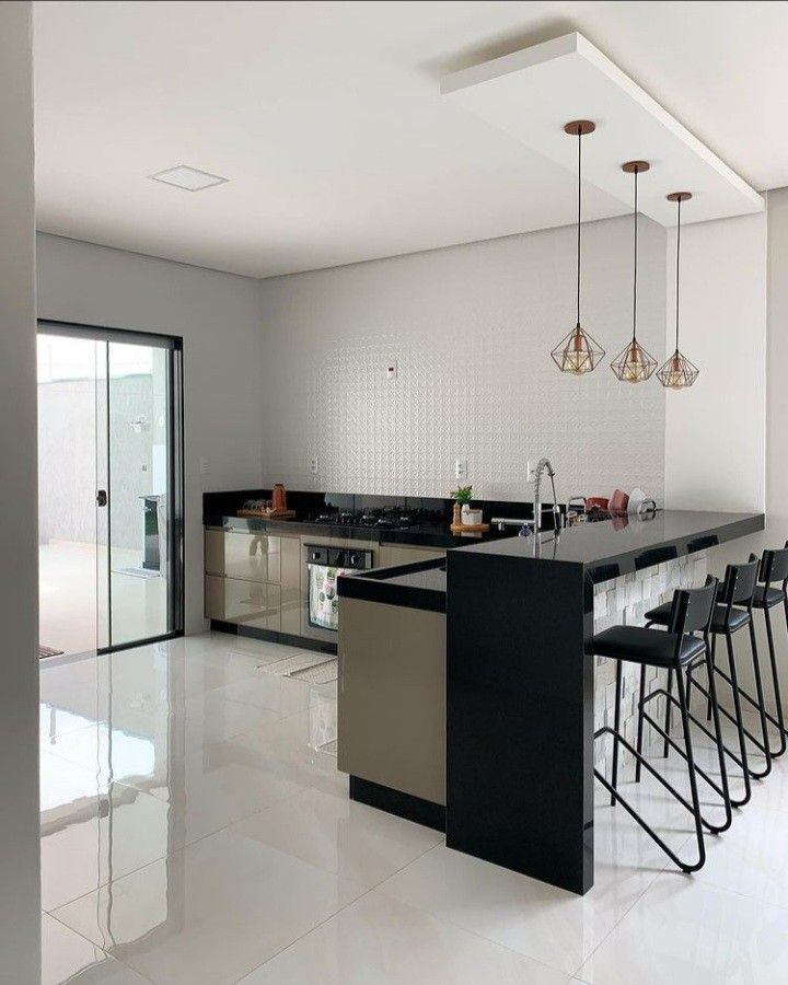 a modern kitchen with black and white countertops, bar stools, and an island