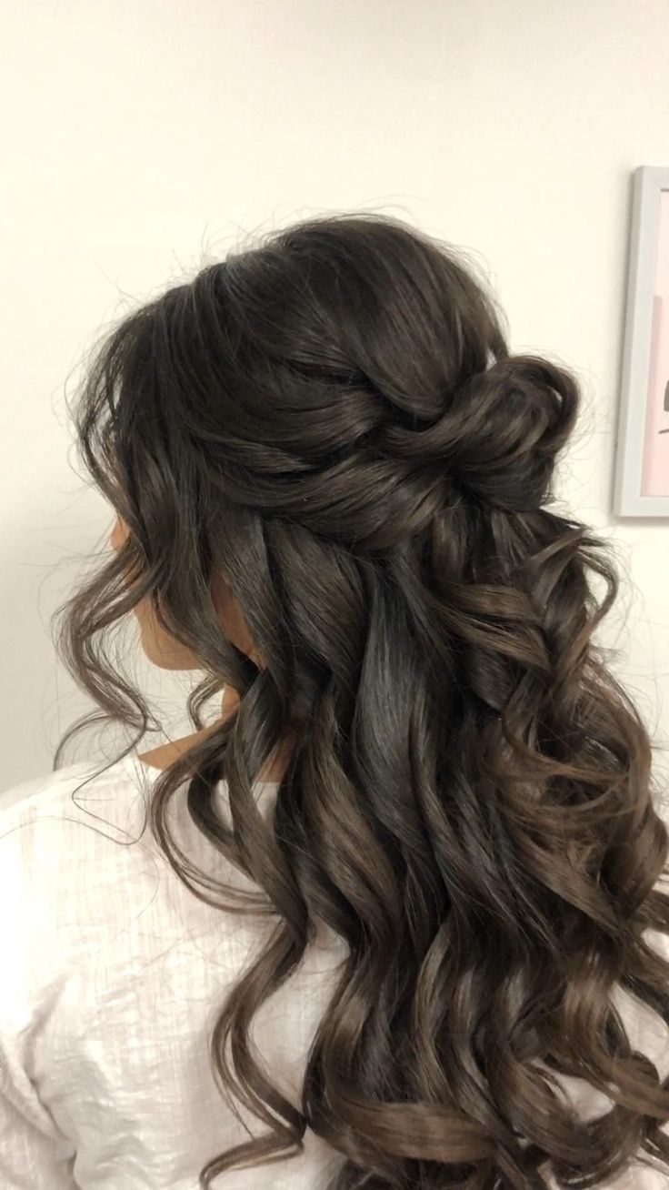 the back of a woman's head with long dark hair and curls in it