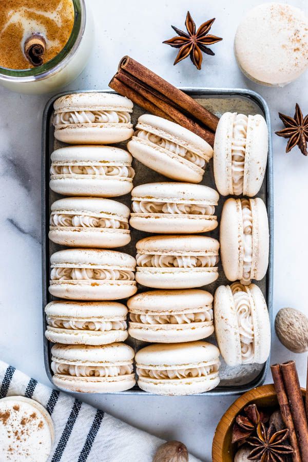 a tray filled with cookies and cinnamons next to anisette on a table