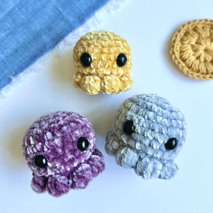 three small crocheted animals sitting next to each other