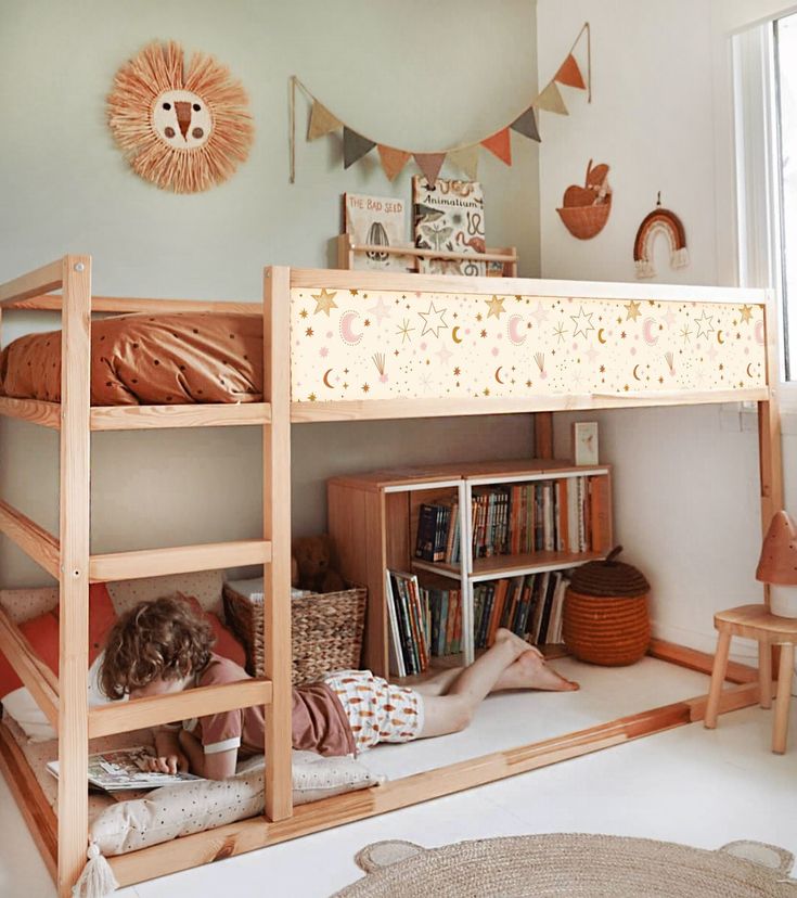 two children sitting on the bottom bunk of a bed in a child's bedroom