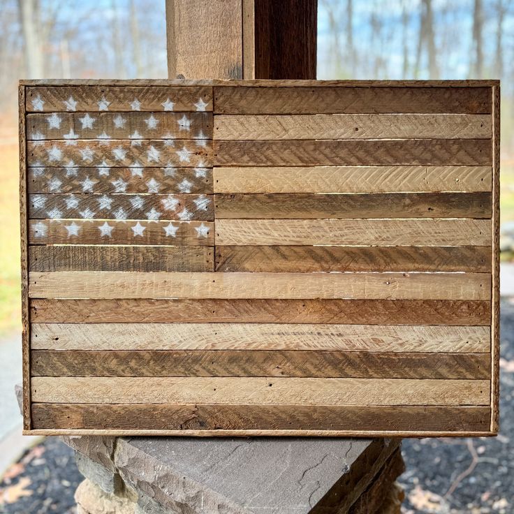 an american flag made out of wood sitting on top of a rock