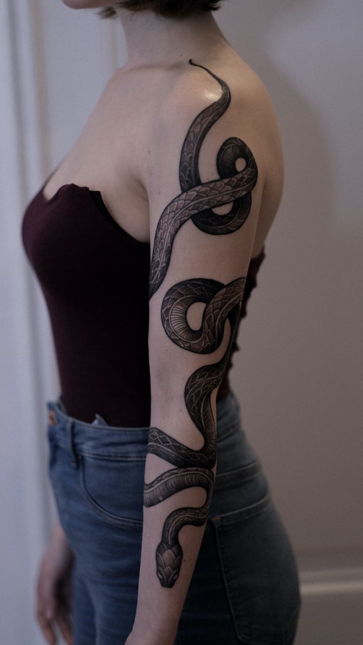 a woman with a snake tattoo on her arm