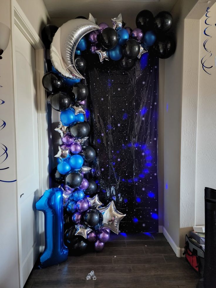 an entrance decorated with balloons and streamers for a new year's eve party