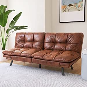 a brown leather couch sitting on top of a wooden floor next to a potted plant