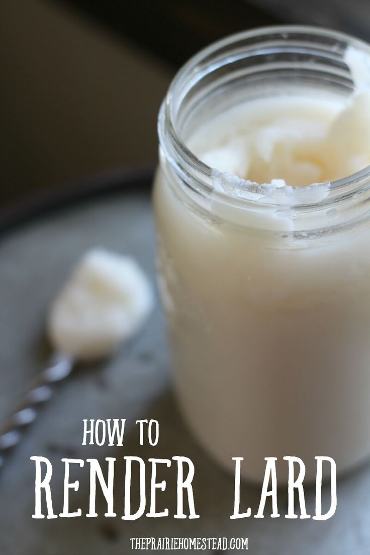 a jar filled with white liquid sitting on top of a metal tray next to a spoon