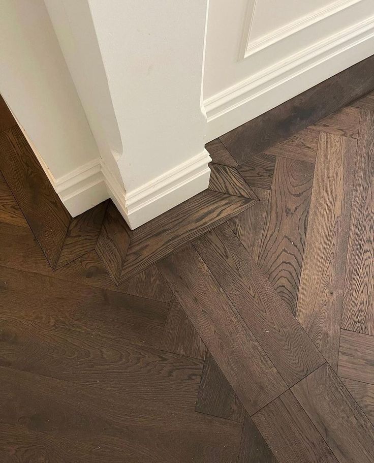 the corner of a room with wood flooring and white trimmings on it