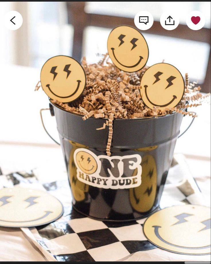 a bucket filled with lots of happy faces on top of a table