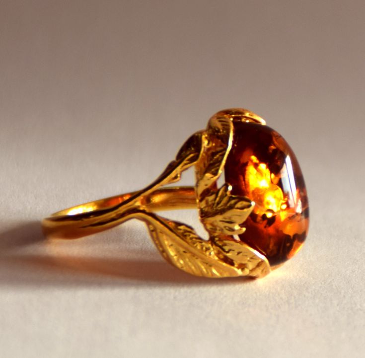 - Beautiful ring made of 14k gold plated 925 silver; - Made with certified Natural Amber from the Baltic Sea, fished on the south coast by our prospectors and processed in our laboratory; - Elegant and classic model, the oval gem surrounded by a refined bright gold decoration creates a splendid effect, which delicately adorns the finger; - Very bright, oval amber of classic brown color; - The perfect match for those who love handcrafted jewellery; - Handcrafted through traditional craft techniqu Luxury Amber Rings Fine Jewelry, Luxury Oval Amber Jewelry, Luxury Amber Open Ring Jewelry, Luxury Amber Topaz Ring For Gift, Luxury Amber Oval Jewelry, Luxury Amber Birthstone Jewelry, Luxury Amber Topaz Ring For Formal Occasions, Elvenyellow Jewelry, Luxury Amber Rings With Polished Finish