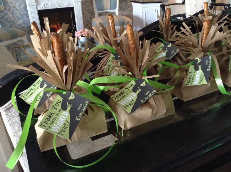 some brown paper bags with green ribbons on top of a black table in front of a fireplace