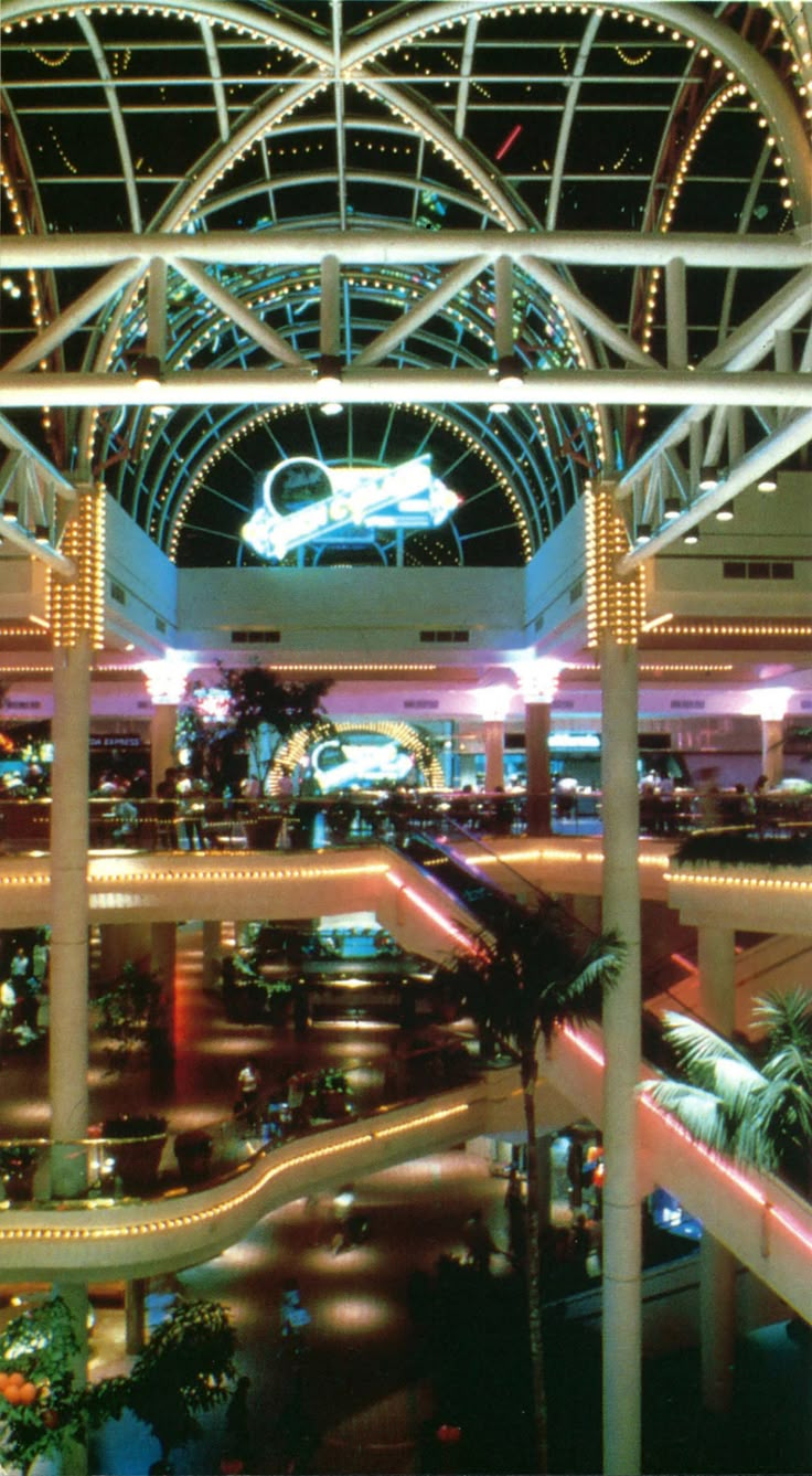 an indoor mall with lights and palm trees