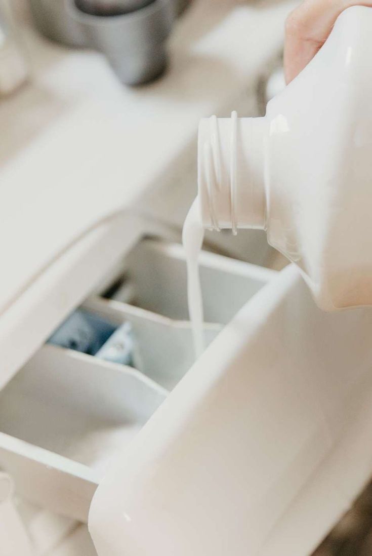 a person pouring milk into a white container